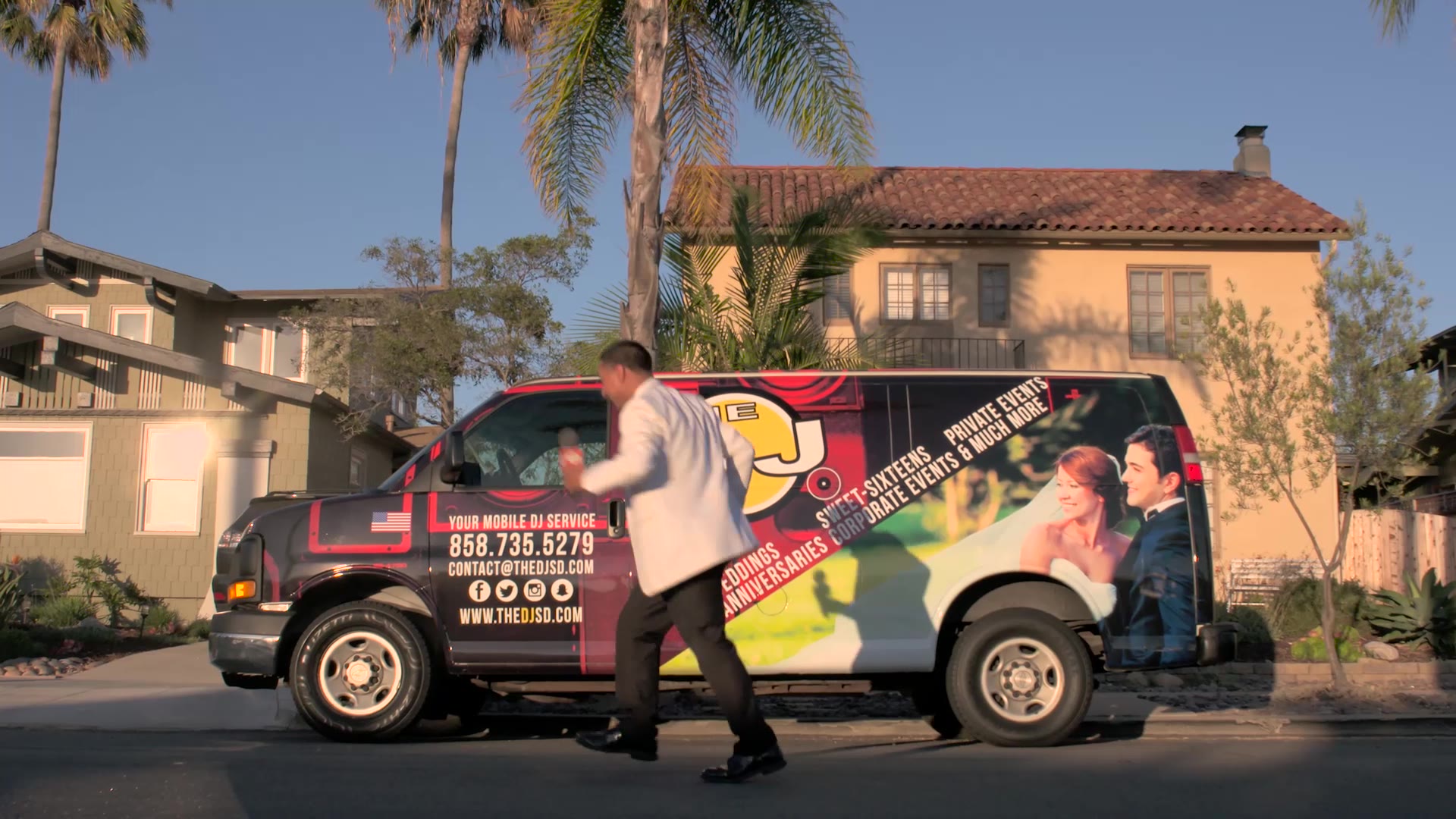 The DJ dancing in the street beside The DJ Company of San Diego van